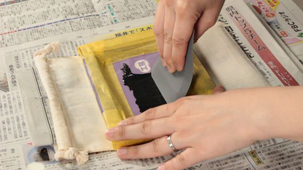 スキージを上から下へと移動させインクを浸透させる